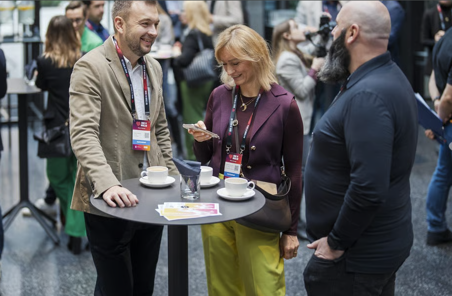 Ludzie przy stolikach rozmawiający w ramach networkingu
